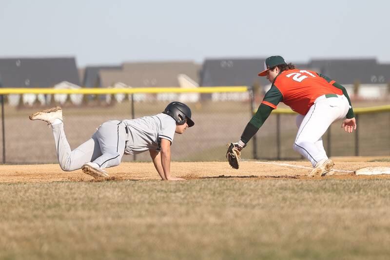 Plainfield East’s Trevor Milka tags out Bolingbrook’s Jonny Carrera as he dives back to first base on Monday, March 27, 2023.