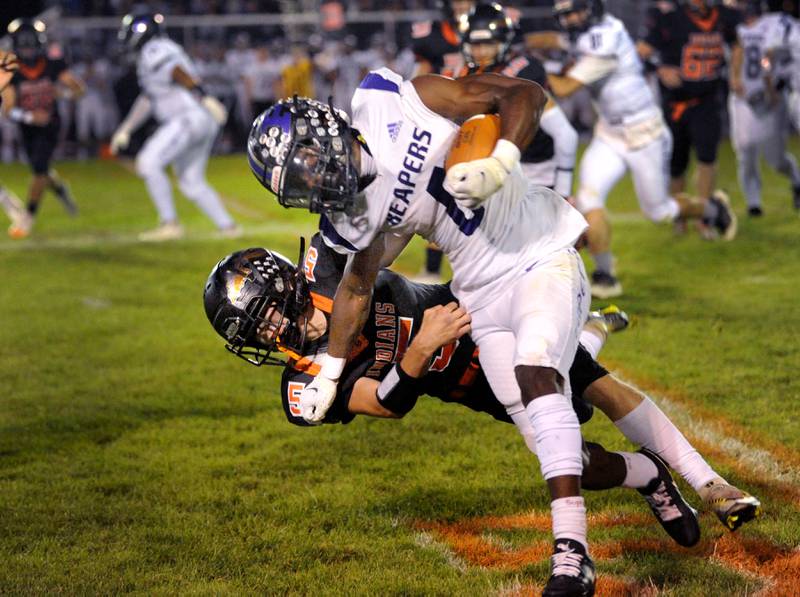 Plano runningback Waleed Johnson (6) gains a first down before being tackled by Sandwich defender Cole Leeper (5) during a varsity football game at Sandwich High School on Friday, Sept. 8, 2023.