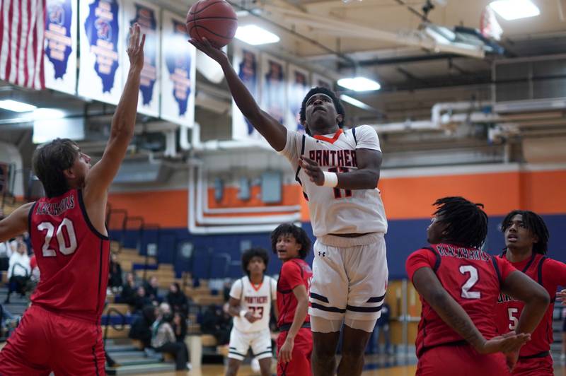 Oswego’s Rodney Richardson (11) shoots the ball in the post against West Aurora's Billy Samp (20) and Calvin Savage (2) during a basketball game at Oswego High School on Friday, Dec 1, 2023.