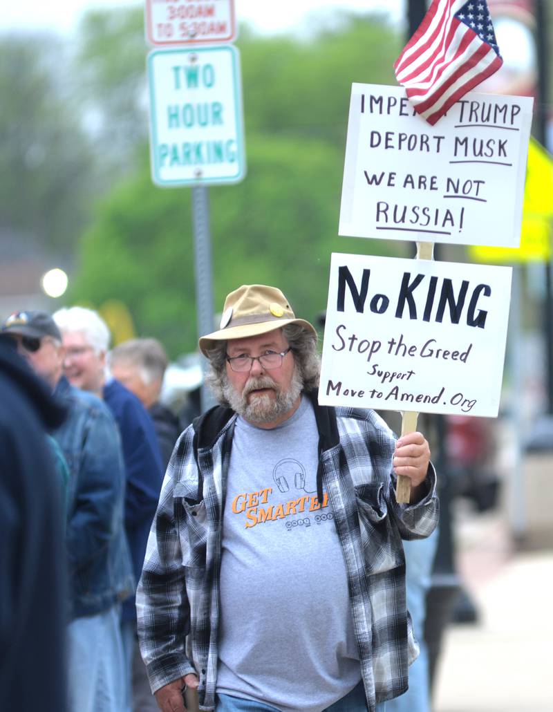 Doug Aken carries two signs at the May Day rally on Thursday, May 1, 2025 in Oregon.