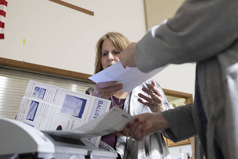 Election judge Deb Donoho helps a voter submit their ballot Tuesday, Nov. 8, 2022 at the Northside Baptist Church in Dixon. Crowds have been steady and at times busy.