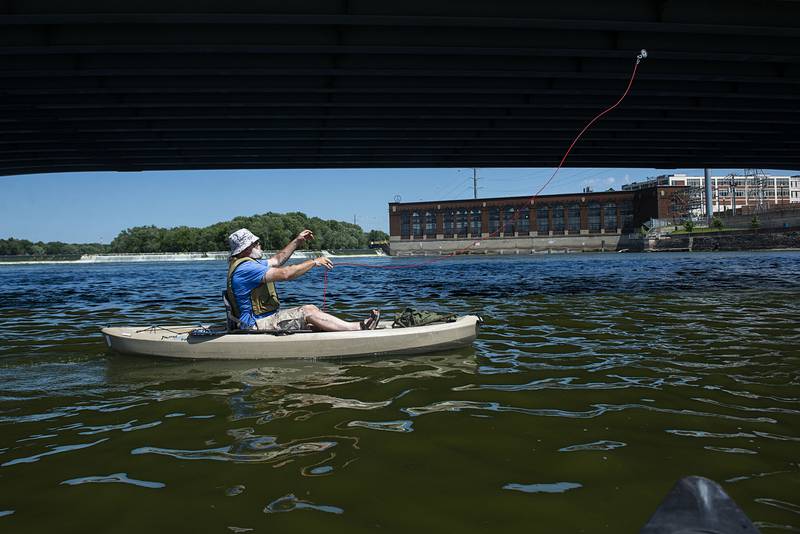 Mark Stach casts the magnet to reel up evidence of the Truesdell bridge disaster from his kayak tethered beneath the Galena Avenue bridge. A couple of unsecured tethers has cost him some of magnets, he said. Luckily, they are reasonably affordable, he added.