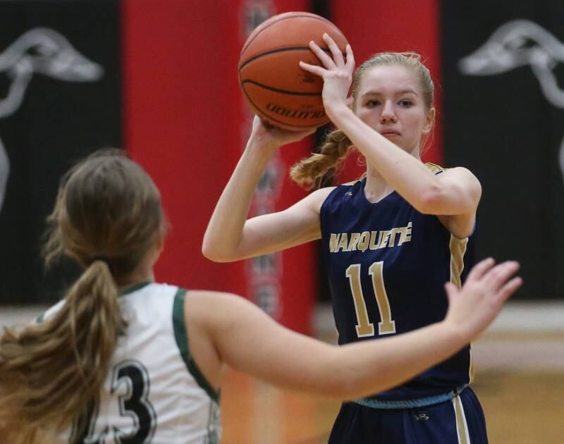 Marquette's Keely Nelson looks to pass the ball around Midland's Maddie Pyles during the Tri-County Conference Tournament third-place game on Thursday, Jan. 18, 2024 at Henry-Senachwine High School.