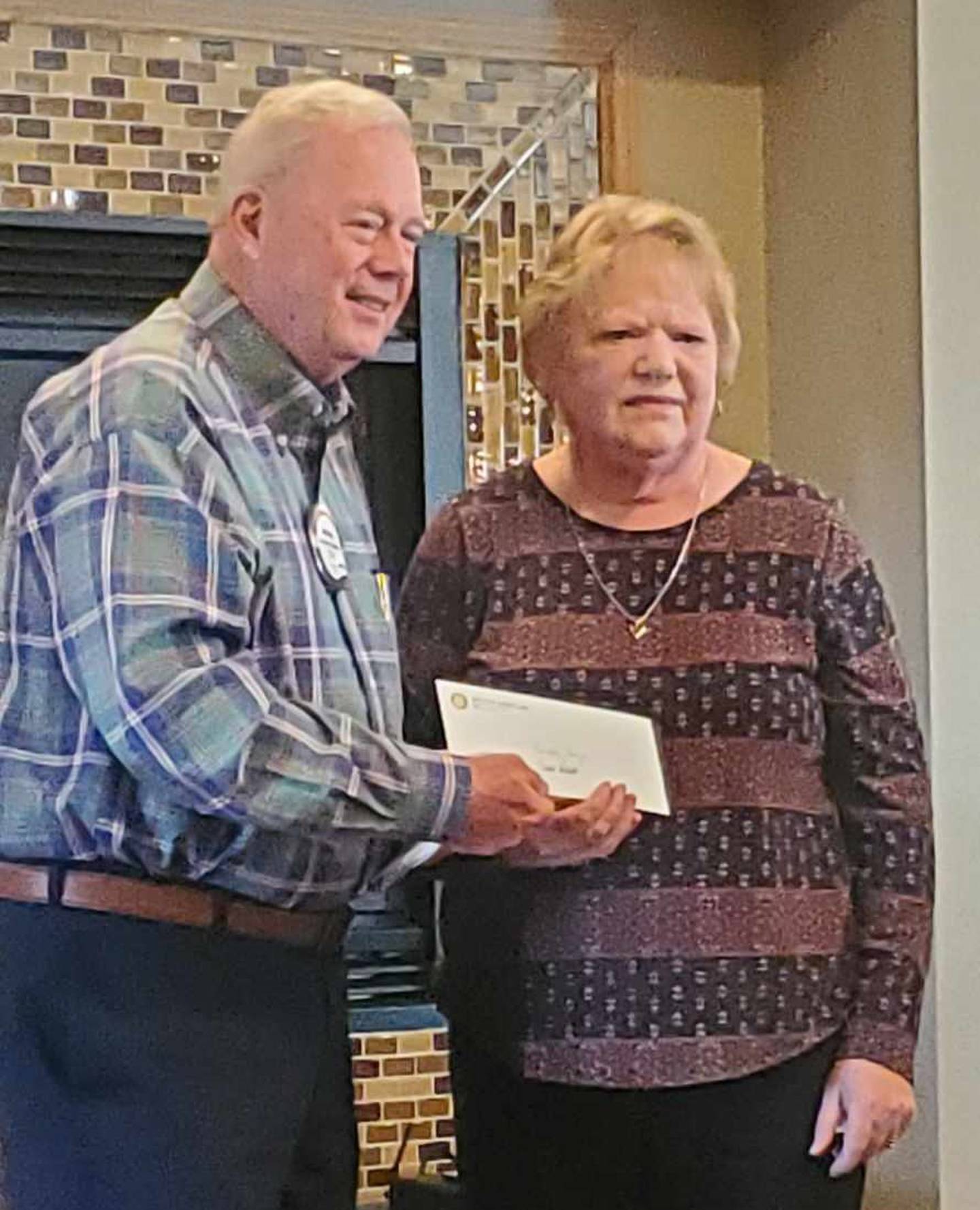 Michael Stutzke presents a check to Diane Heller representing Princeton Buddy Bags.