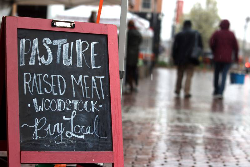 People stroll during the farmers market Saturday, April 29, 2023, on the historic Woodstock Square.