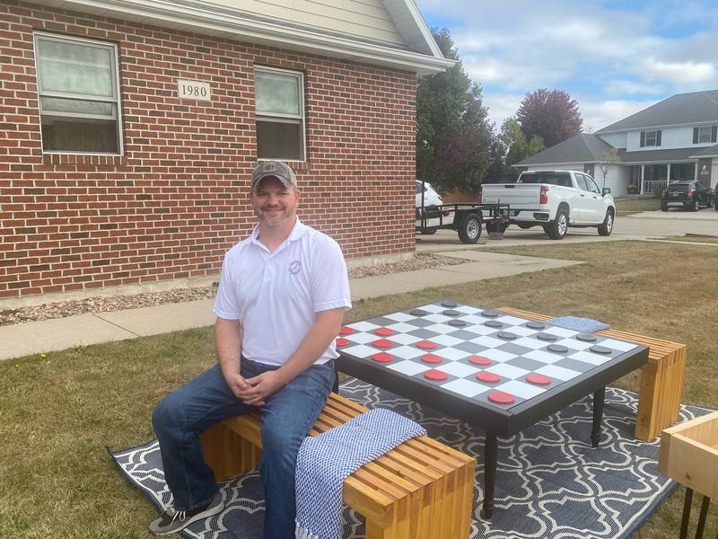 Kyle Borchers, owner of AppleJax Creations, with his handmade giant checkers game.