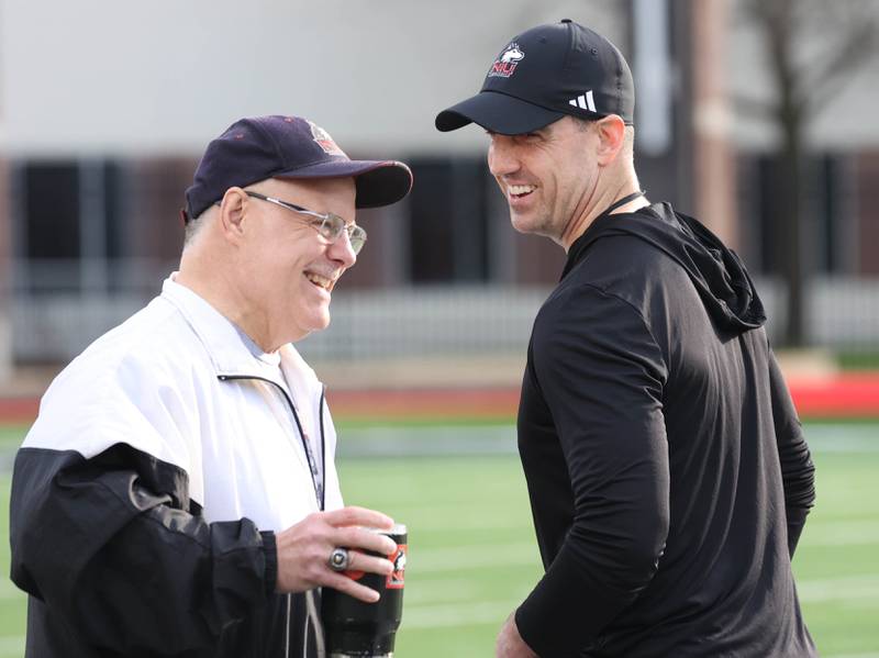 Northern Illinois University head football coach Rob Harley (right) enjoys a moment Tuesday, April 14, 2026, during spring practice in Huskie Stadium at NIU in DeKalb.