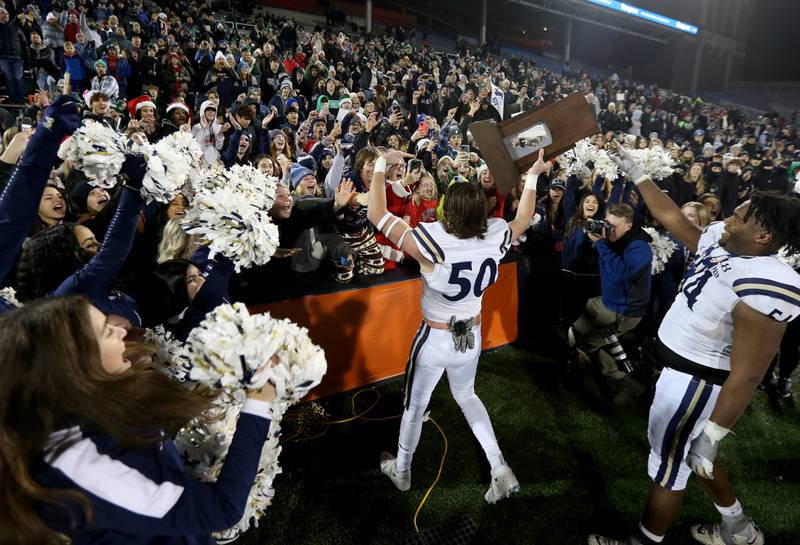 IC Catholic's Nico Palmieri (50) brings the Class 3A championship trophy to the Knight super fans after defeating Williamsville in the Class 3A State Championship on Friday, Nov. 25, 2022 at Memorial Stadium in Champaign.