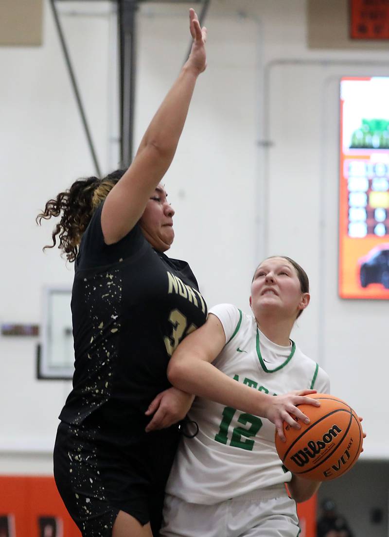Crystal Lake South's Gaby Dzik is founded by Grayslake North's Sara Robledo Carrasco as she drives to the basket during a Northern Illinois Holiday Classic semifinal girl basketball game on Tuesday, Dec. 16, 2025, at McHenry High School.