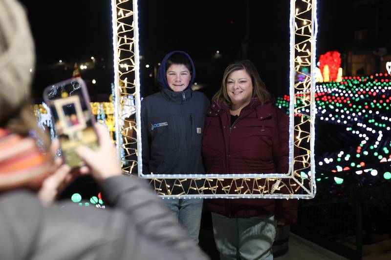 Jenn Galloy and her son Noah have there photo taken at a lighted picture frame at the GLOW Holiday Festival at Slammers Stadium on Wednesday, Nov. 27, 2024 in Joliet.