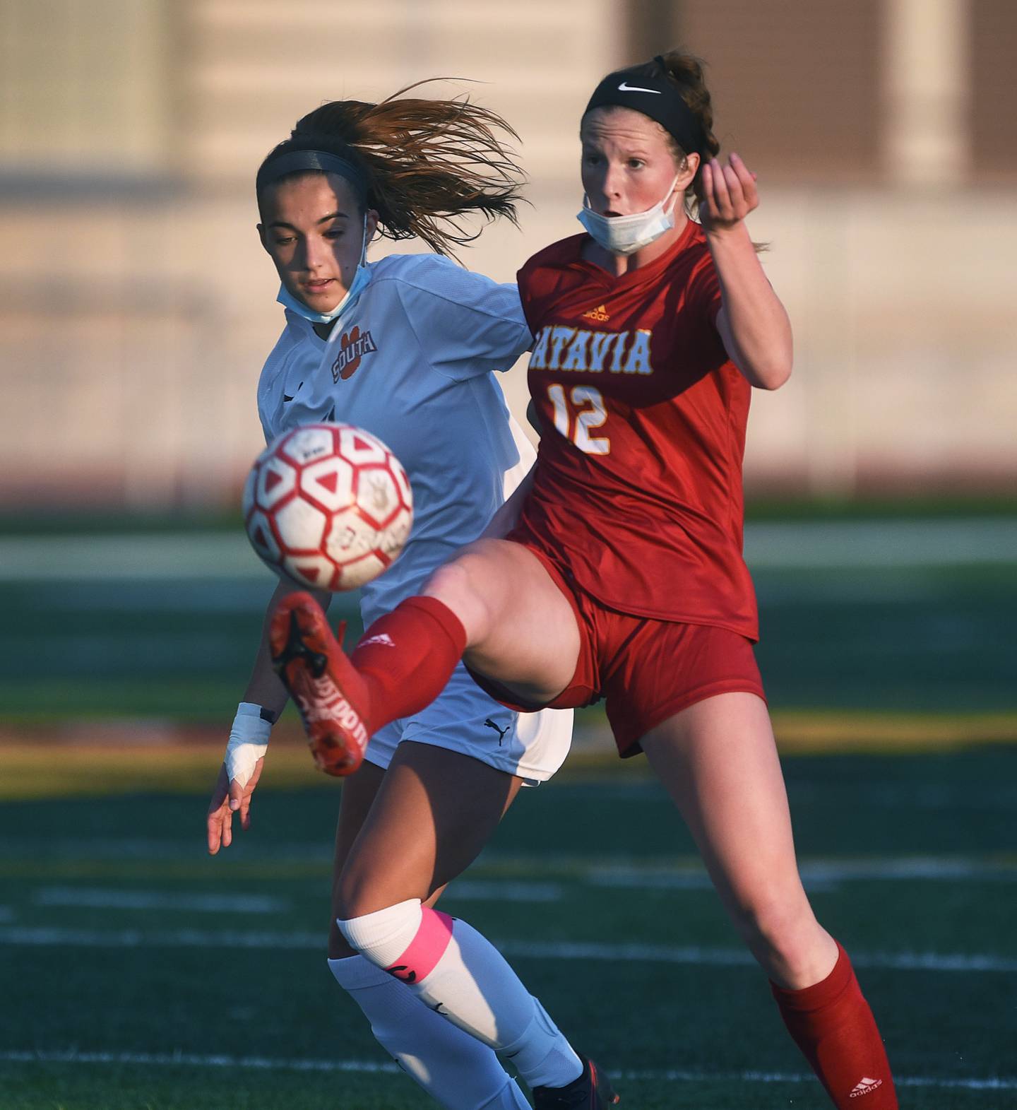 Batavia's Johanna Shubert (12) keeps the ball away from Wheaton Warrenville South's Melisa Hadzic during Thursday's girls soccer game in Batavia.