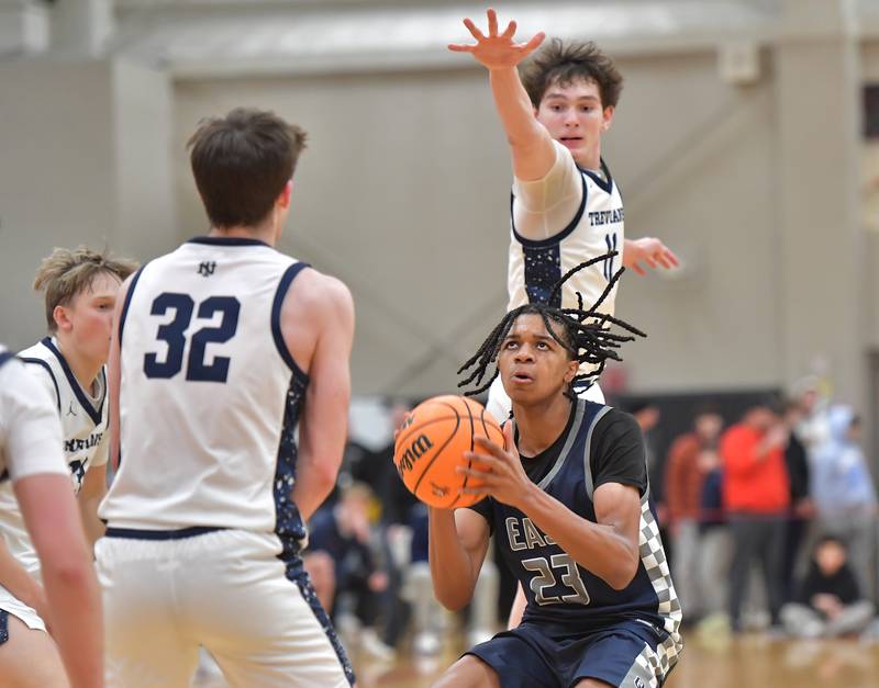 Oswego East’s Mason Lockett (23) starts to shoot as New Trier’s Matthew Logue hovers overhead during a When Sides Collide Shootout game on January 24, 2026 at Benet Academy in Lisle.