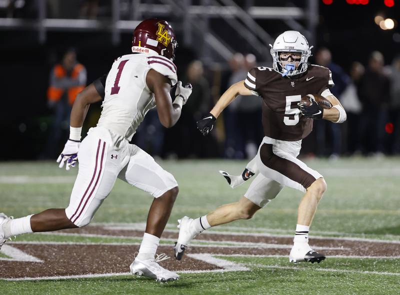 Mt. Carmel's Cooper Lehman (5) runs the ball during the varsity football game between Loyola Academy and Mt. Carmel high school on Friday, Oct. 25, 2024 in Chicago.