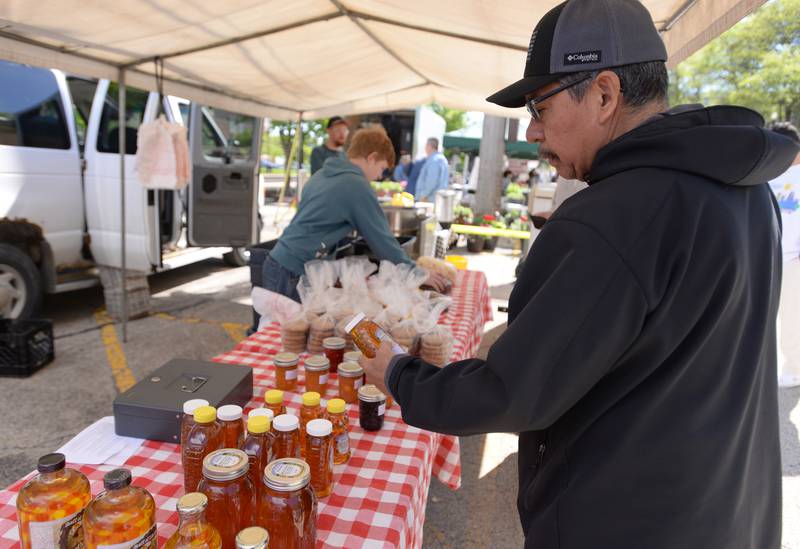 Esteban Leon of Westmont looks over the variety of honeys at the Downers Grove Farmers Market Saturday May 11, 2024.