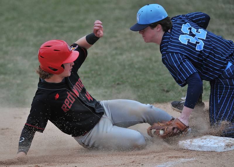 Benet's Jackson Bayer is tagged out at third base by Nazareth's Finn O'Meara (32) while trying to advance on a passed ball during a game on Apr. 12, 2022 at Nazareth Academy in LaGrange Park.