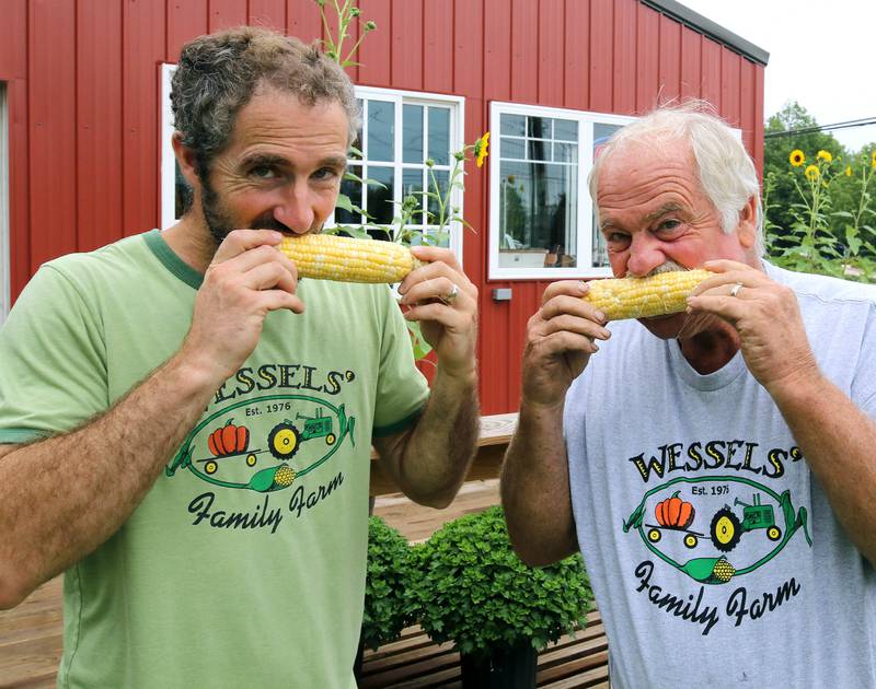 Wessels' Family Farm owners Rob Wessels (right) and his son Brandon try some of their sweet corn Tuesday, Aug. 19, 2025, at Wessels' Family Farm Market in DeKalb. They are preparing to be a big part of  this weekend’s Corn Fest.