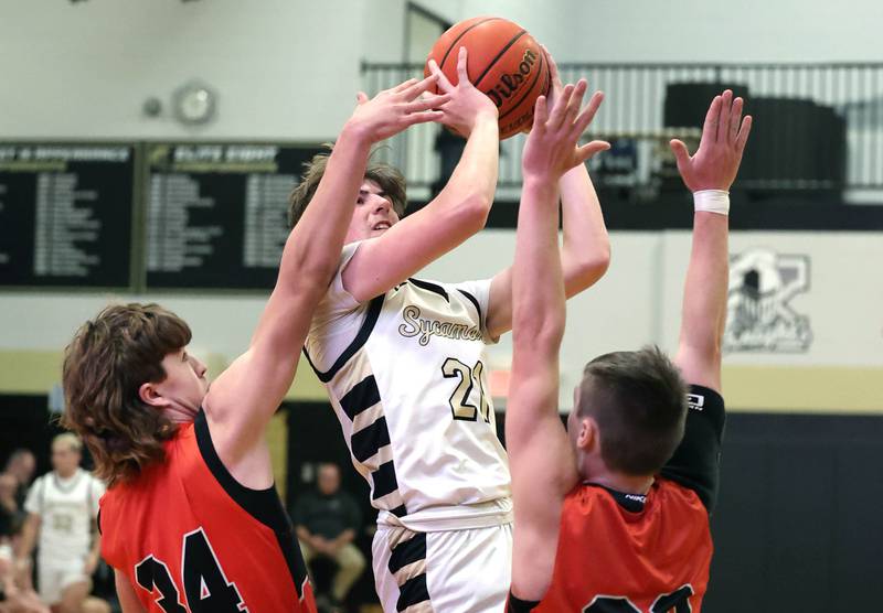 Sycamore's Ben Larry shoots the ball over Sandwich's Braden Behringer (left) and Sandwich's Chance Lange during their game Friday, Nov. 24, 2023, in the Leland G. Strombom Holiday Tournament at Sycamore High School.