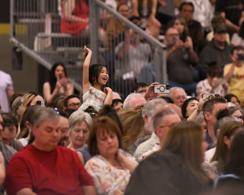 A young attendee is all smiles and waves to her graduate during the Class of 2026 Commencement on Sunday, May 24, 2026, held at Sycamore High School.
