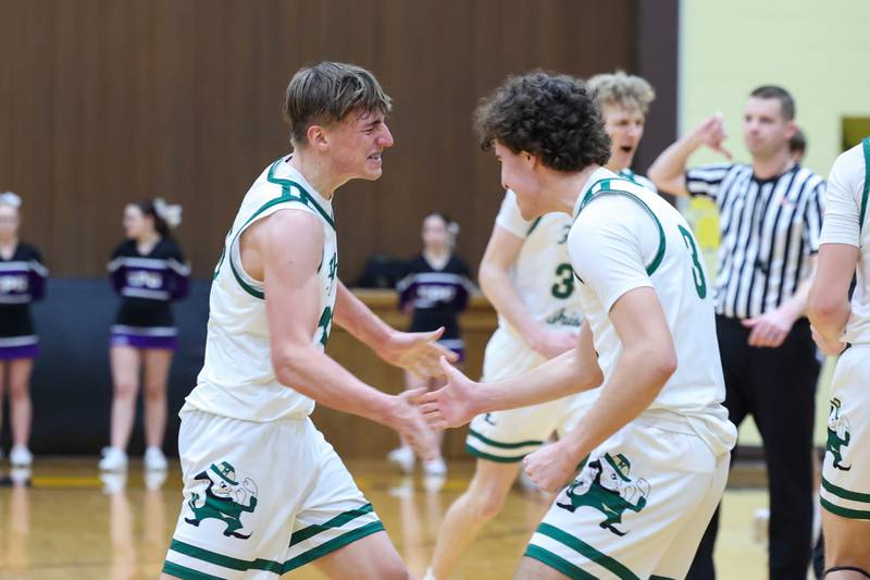 Bishop McNamara's Coen Demack, left, excitedly high fives teammate Preston Payne as he is subbed off the court near the end of the game during the Fightin' Irish's 66-52 victory over El Paso-Gridley in the IHSA Class 2A Herscher Regional championship on Friday, Feb. 27, 2026.