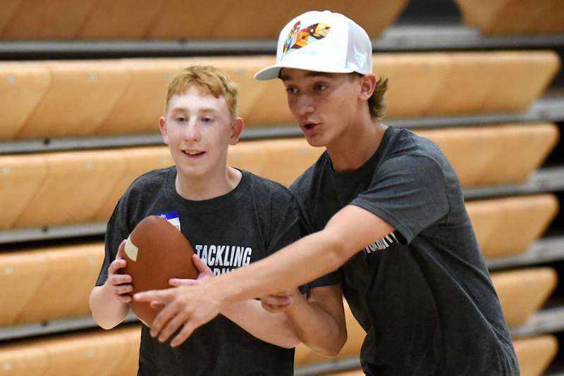 Jackson Dickte, left, receives instruction from David Barwegen during Watseka's Tackling Disabilities football camp Saturday, July 26, 2025.