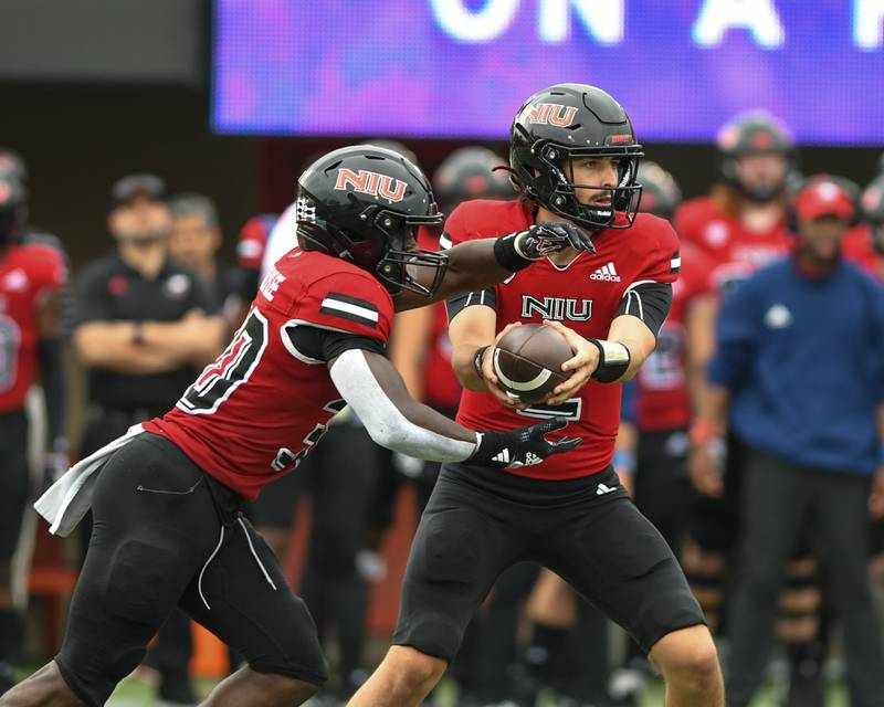 Northern Illinois Huskies QB Ethan Hampton, right, hands the ball to teammate Harrison Waylee during the third quarter Saturday Sep. 17 while taking on Vanderbilt at Huskie Stadium in DeKalb.