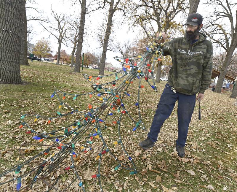 Rob Sharisky assembles a lighted Christmas tree as Light Up Streator volunteers added a holiday touch to the Mistletoe Market  at City Park Saturday .