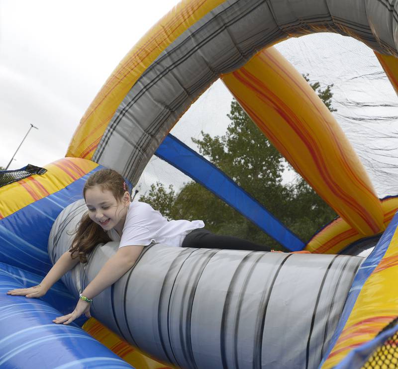 Baylee Christen climbs though a bounce house Saturday, Sept. 28, 2024, at the Jordan bblock during the annual Scarecrow Fest in Ottawa.