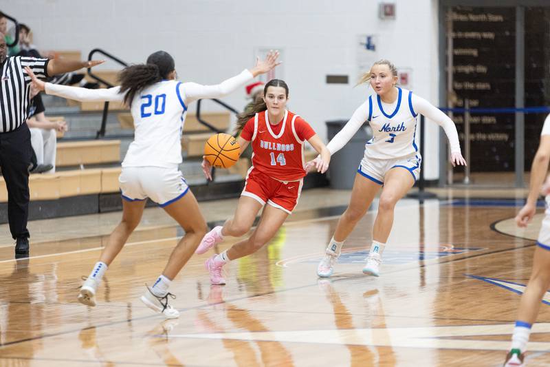 Batavia's Eva Holzl looks to avoid the double team by St. Charles North's Sydney Johnson (20) and Brianna Buno on Friday, Dec.12,2025 in st. Charles.