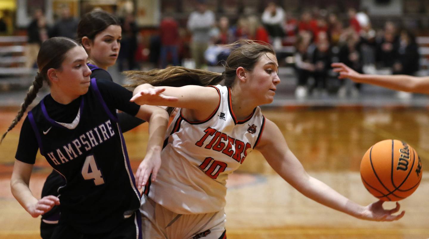 Crystal Lake Central's Samantha Pottorff (right) makes a finger tip rebound in front of Hampshire's Peyton McCarthy (left)  and Veronica Dumoulin (center) during a Fox Valley Conference basketball game on Friday, Feb. 7, 2025, at Crystal Lake Central High School.