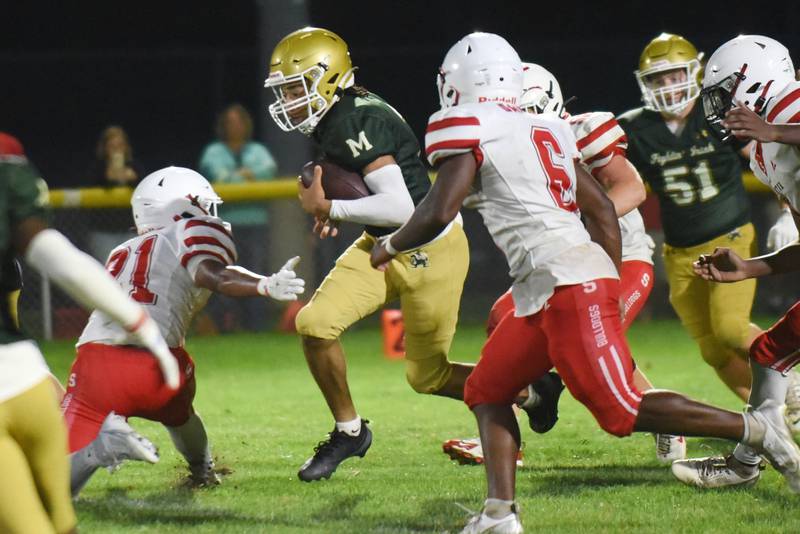 Bishop McNamara's Micah Lee, center, splits the Streator defense during a Week 0 scrimmage at Bishop McNamara Friday, Aug. 22, 2025.