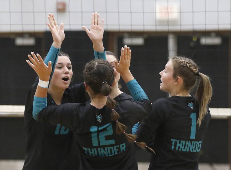 Woodstock North's Ava Kardaras, (left) Gabriella Schefke, (center) and Tayler Menzel (right) celebrate a point during a Kishwaukee River Conference volleyball match against Richmond-Burton on Monday, Sept. 15, 2025, at the Woodstock North High School.