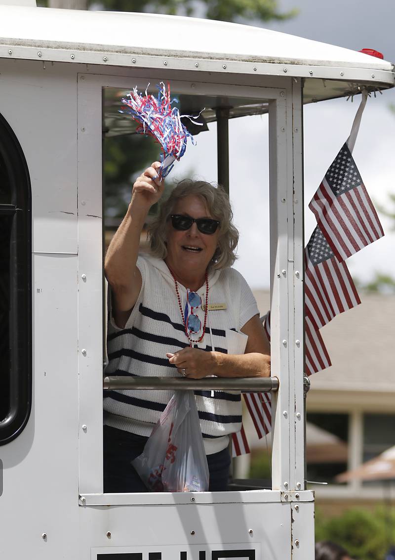 Sue McArdle waves from the Service League of Crystal Lake’s float on Sunday, July 6, 2024, during Crystal Lake’s annual Independence Day Parade on Dole Avenue in Crystal Lake.