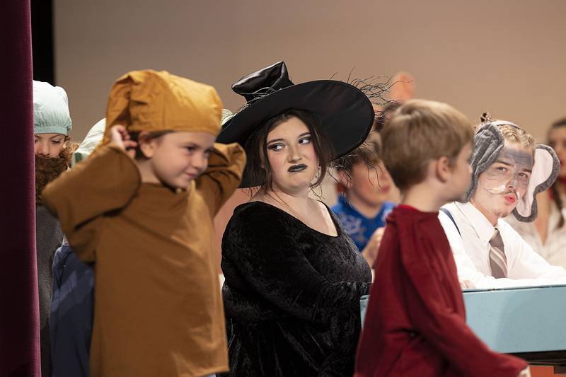 Playing the part of the Wicked Witch, Leslie Pettorini, glares at the dwarves of Snow White's tale as they make their way on stage during Dixon High School’s rehearsal of the play "Fairytale Courtroom."
