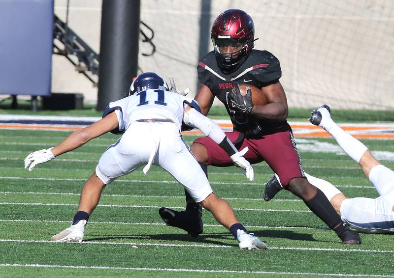 Peoria's Malachi Washington looks to get by Nazareth's James Penley during their IHSA Class 5A state championship game Saturday, Nov. 26, 2022, in Memorial Stadium at the University of Illinois in Champaign.