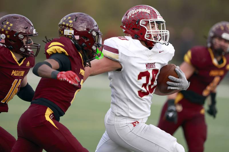 Morris' Brady Babington (30) moves through a host of Montini players during the IHSA Class 4A semifinals football playoff game Saturday, Nov. 22, 2025 in Lombard.