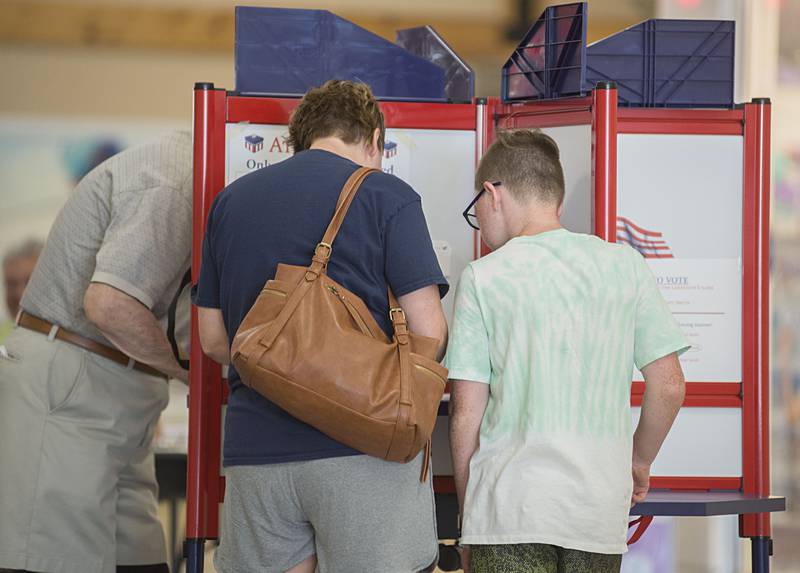 Rana Smith shows her son Evan, 11, the voting process Tuesday, June 28, 2022 at the mall in Sterling. “It’s very important to come out to vote,” Smith said about the life lesson.