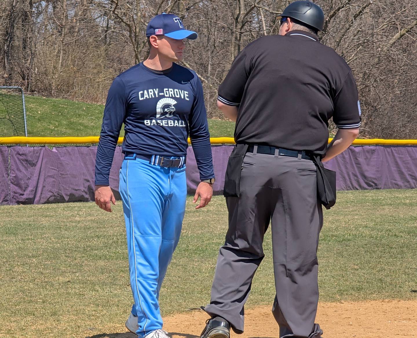 Cary-Grove baseball coach Kyle Williams talks to the home plate umpire during the seventh inning of the Trojans' game against Wauconda on Saturday, April 12, 2025, in Wauconda.