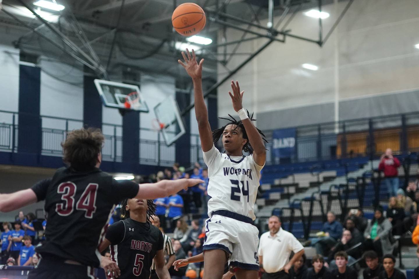 Oswego East's Mason Lockett IV (24) shoots the ball against Plainfield North's Quintin Wiencek (34) during a basketball game at Oswego East High School on Friday, Dec. 6, 2024.