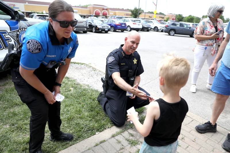 Batavia Police Officer Jamie Goschey and Chief Shawn Mazza hand out coupons for free ice cream scoops outside the Batavia Creamery on Thursday, June 6, 2024.