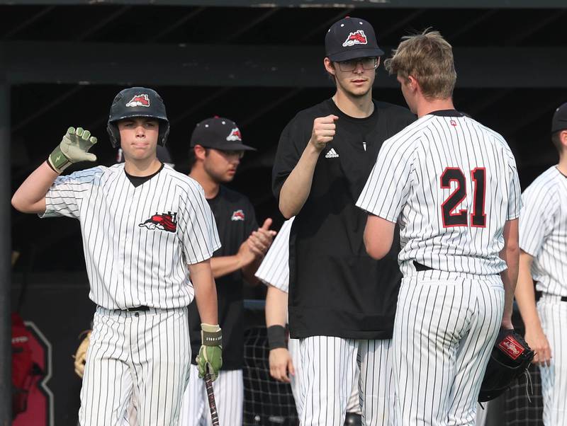 Fulton pitcher Chase Dykstra is congratulated by teammates after getting out of a bases loaded jam Monday, June 2, 2025, during their Class 1A supersectional game against Marquette at Northern Illinois University in DeKalb.