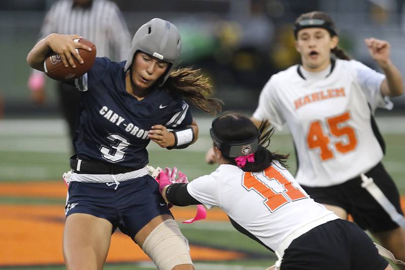 Cary-Grove's Kennedy Manning tries to get away from Harlem’s Mel Ellis during an IHSA McHenry Sectional semifinal girls flag football game on Monday, Oct. 13, 2025, at McCracken Field in McHenry.