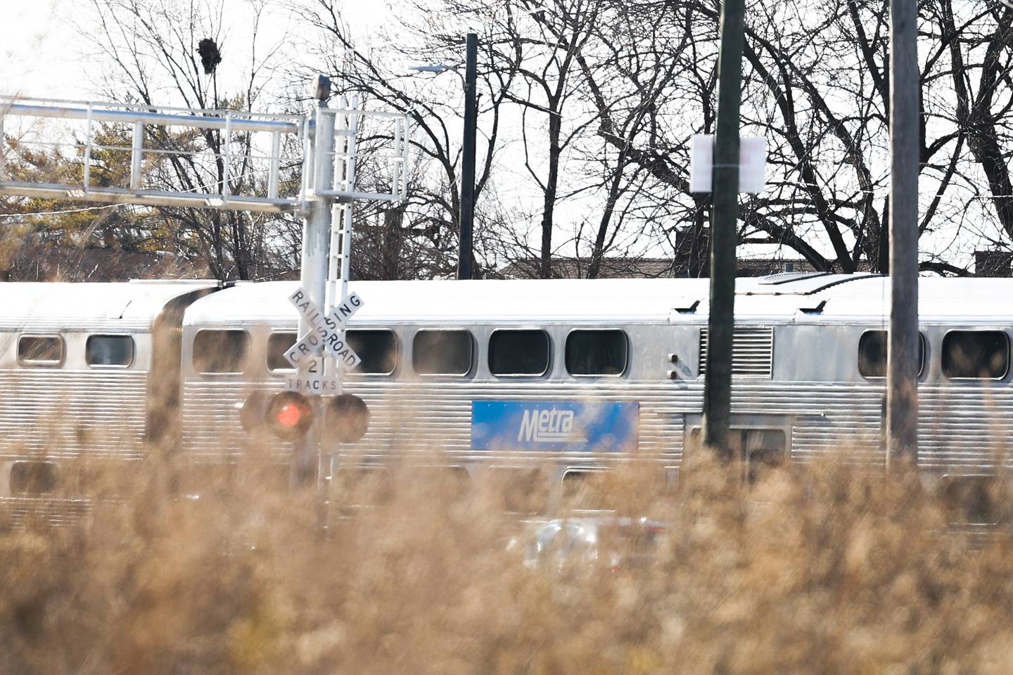 A Metra train passes through a railroad crossing.