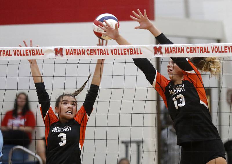 McHenry's Ella Jenkins and Alissa Ricci try and clock the ball during a nonconference volleyball match against Marian Central Monday, Aug. 28, 2023, at Marian Central Catholic High School.