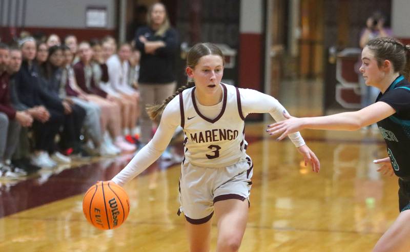 Marengo’s Maggie Hanson moves with the ball against Woodstock North in varsity girls basketball on Tuesday, Dec. 2, 2025, at Marengo High School in Marengo.