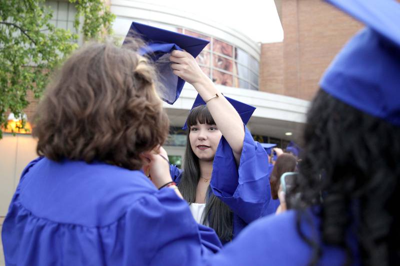 Lyons Township graduate Calla Montana helps classmate Lily Myers with her cap before the school’s 2023 commencement ceremony in Western Springs on Wednesday, May 31, 2023.
