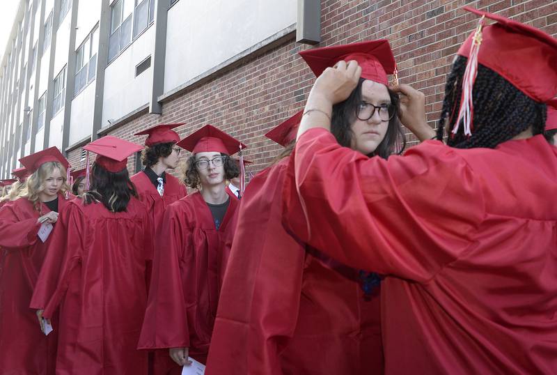 Graduate Kylin Buckingham receives some help with the placement of her cap from fellow classmate Mercedez Bruce prior to the graduation ceremony Friday, May 26, 2023, at Ottawa High School.