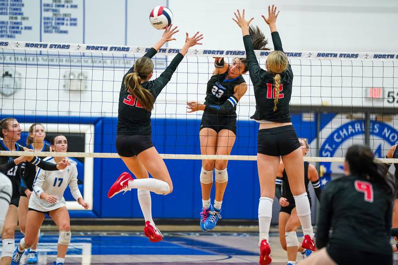 St. Charles North's Haley Burgdorf (23) executes a kill against Huntley’s Izzy Whitehouse  (32) and Summer Massow (12) during a non-conference match at St. Charles North High School on Wednesday, Sept. 3, 2025.