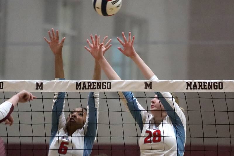 Marian Central’s Kalia Parris, left, and Nola Midday block in IHSA Class 2A  Regional volleyball action on Monday, Oct. 28, 2024, at  Marengo High School  in Marengo.