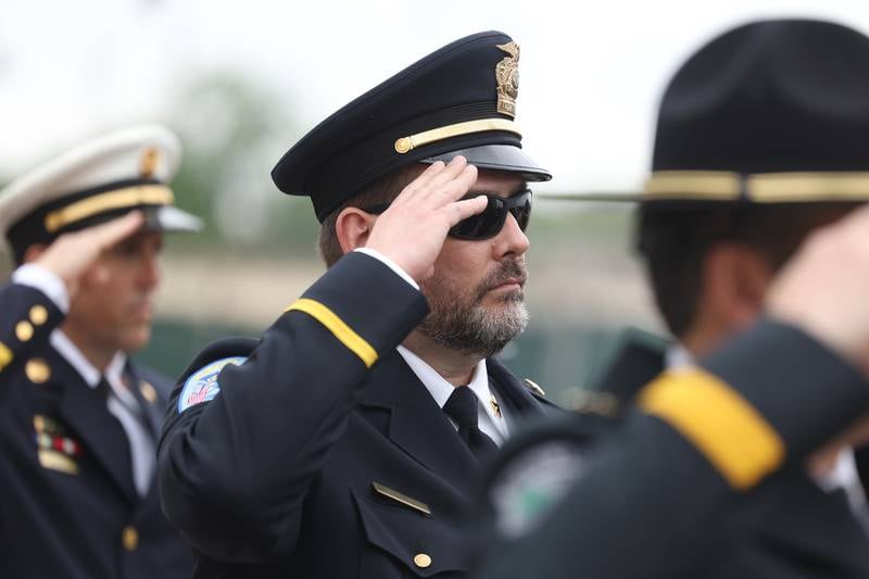 A Crest Hill police officer salutes during the National Anthem during the Will County Law Enforcement Memorial ceremony on Thursday, May 9, 2024 in downtown Joliet.