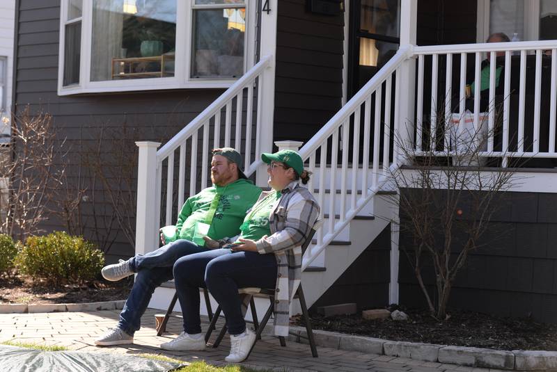Zack and Dayle Klingberg of Chicago enjoy the view of the Elmhurst St. Patrick's Day Parade outside their friends home Saturday, March 9, 2024.